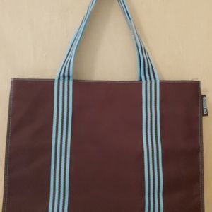 Domino fashion bag made of durable nylon chocolate with teal striped straps.